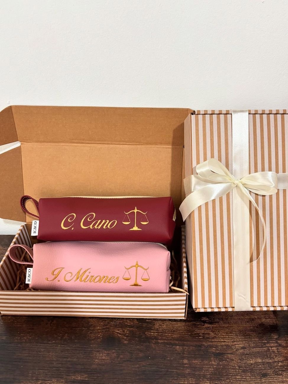 Dos estuches, vino y rosado, con nombres y balanza de la justicia en caja de regalo